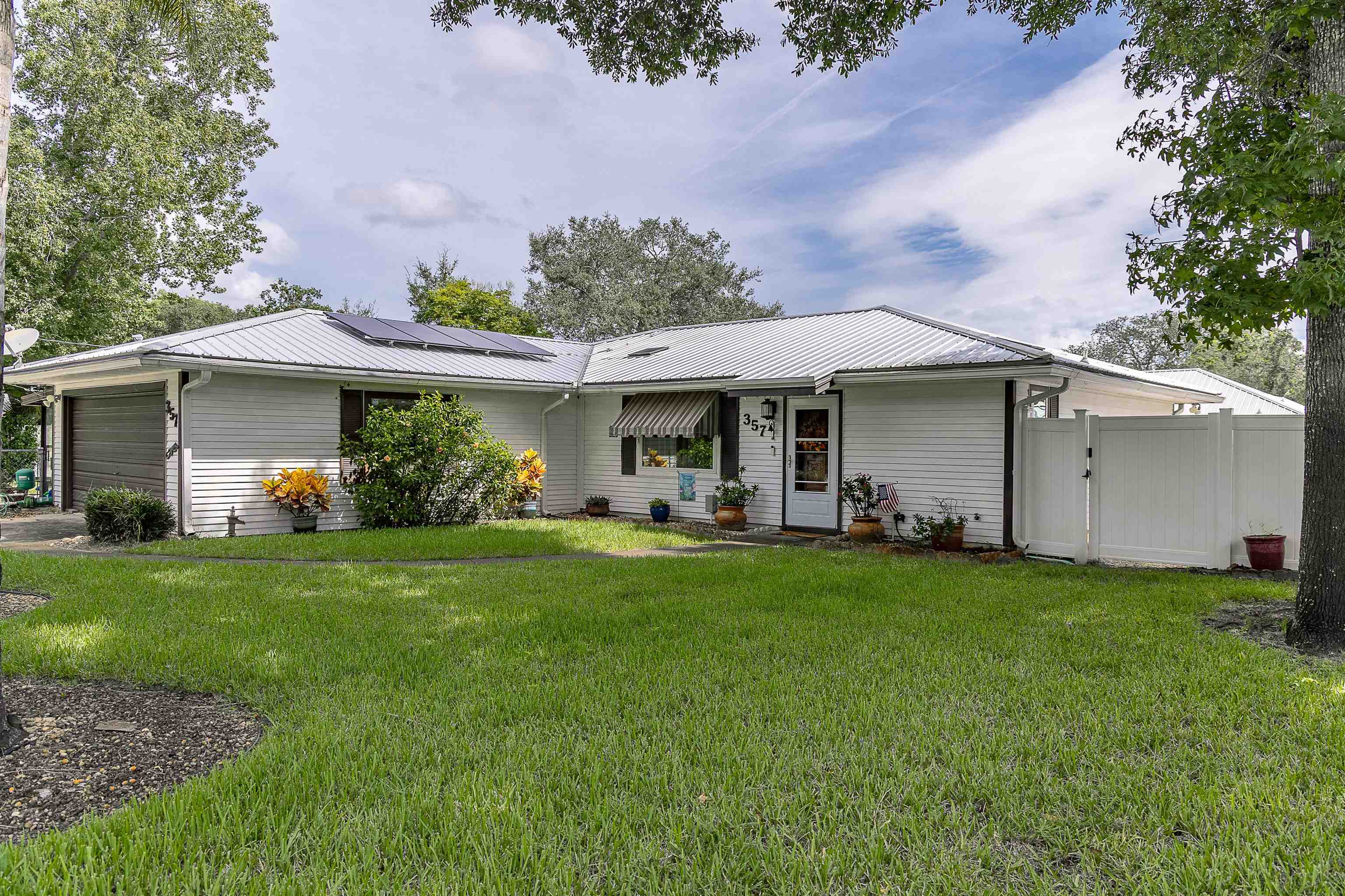 357 Orchis Road St. Augustine, FL 32086 - Photo 1 of 54 a front view of a house with a garden and porch