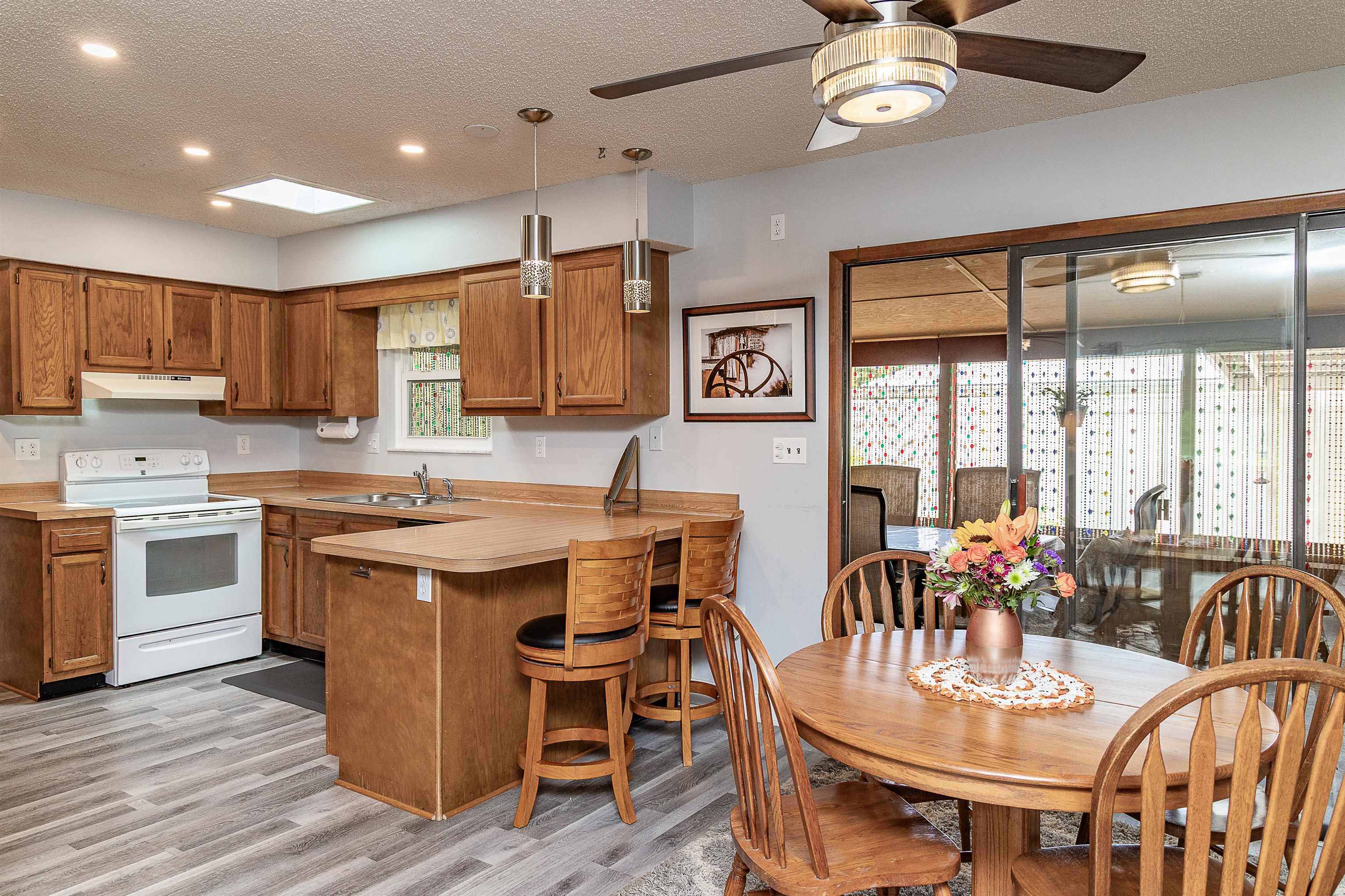 357 Orchis Road St. Augustine, FL 32086 - Photo 25 of 54 a open kitchen with stainless steel appliances granite countertop a stove top oven a refrigerator a dining table and chairs with wooden floor