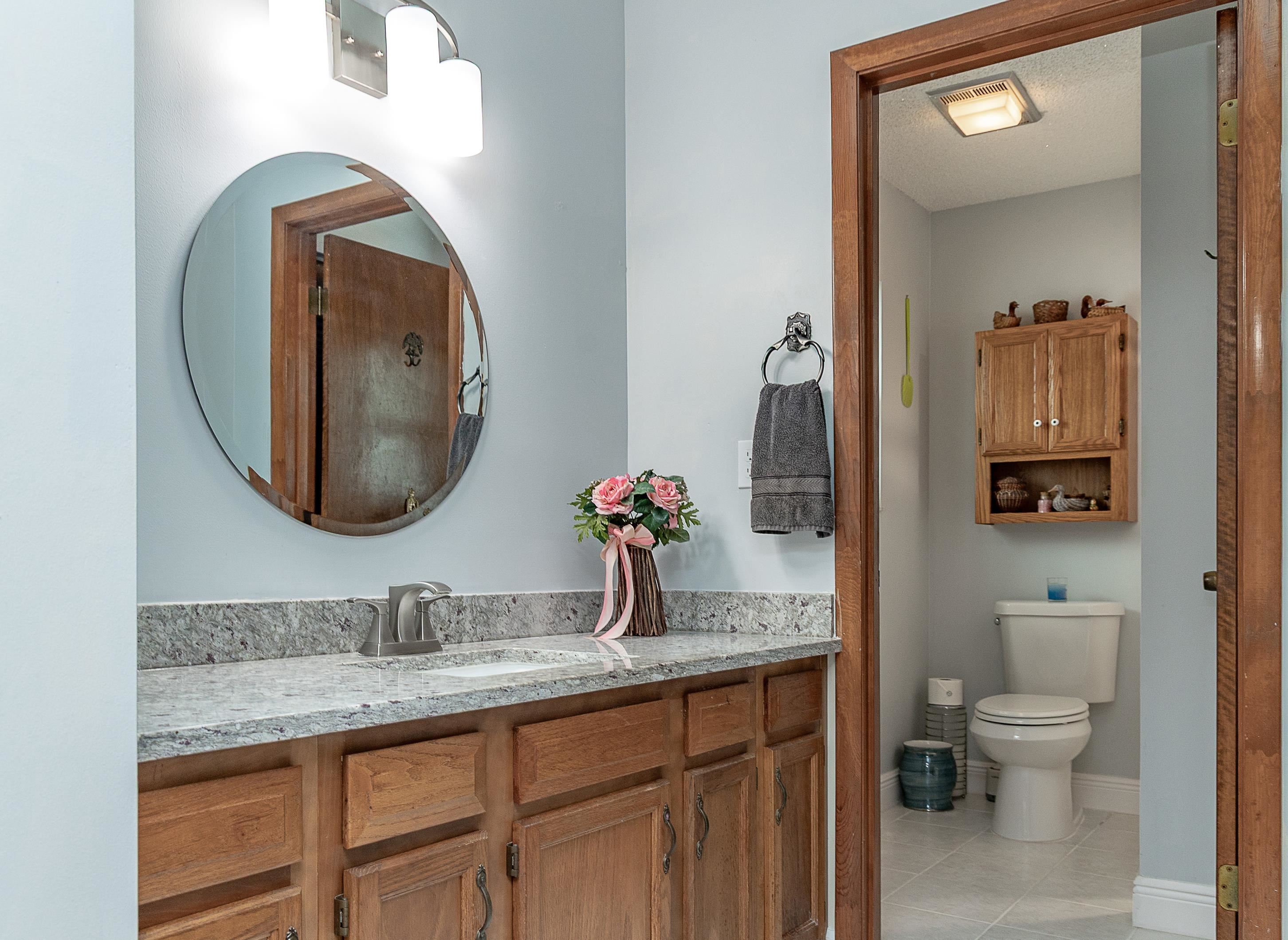 357 Orchis Road St. Augustine, FL 32086 - Photo 34 of 54 a bathroom with a toilet a sink and mirror