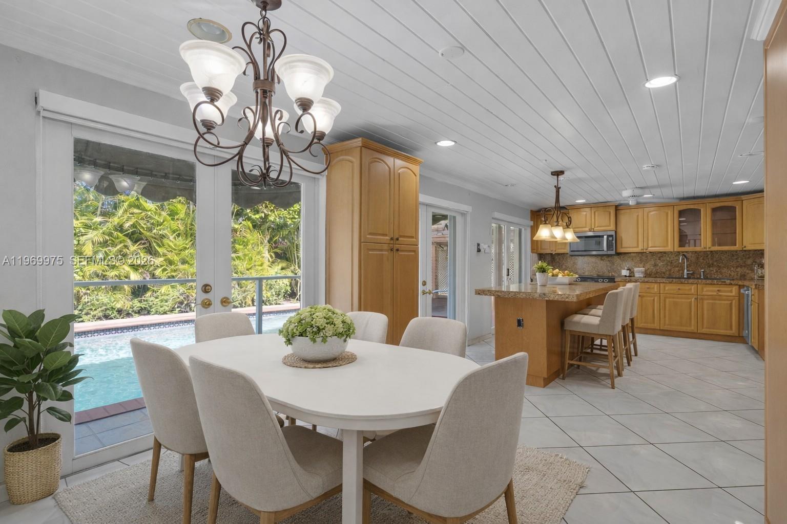7941 Southwest 18th Terrace Miami, FL 33155 - Photo 12 of 60 a dining room filled chandelier and kitchen view