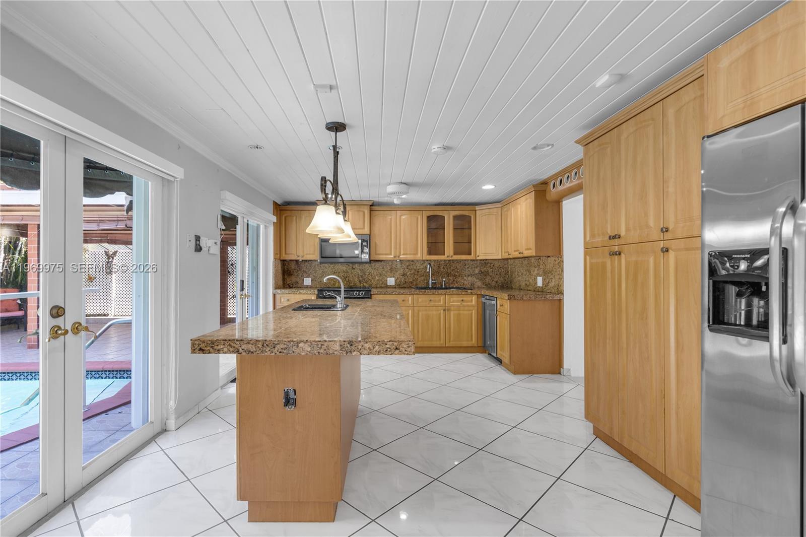 7941 Southwest 18th Terrace Miami, FL 33155 - Photo 14 of 60 a kitchen with stainless steel appliances kitchen island granite countertop a refrigerator and a sink