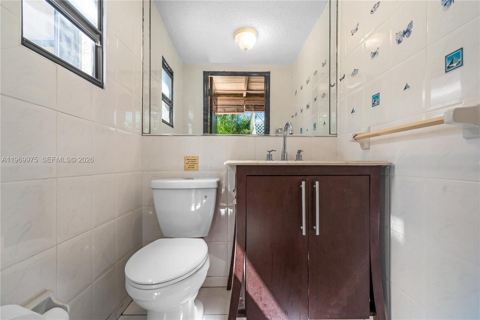 7941 Southwest 18th Terrace Miami, FL 33155 - Photo 49 of 60 a bathroom with a granite countertop toilet sink and mirror