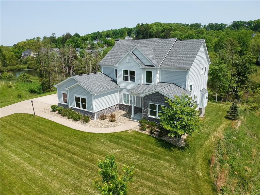 aerial view of a house with a big yard potted plants and large tree