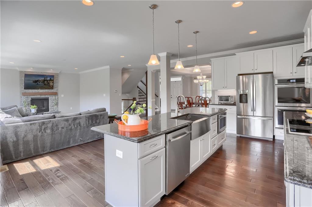 237 Tamarack Drive Gibsonia, PA 15044 - Photo 17 of 48 a kitchen with stainless steel appliances granite countertop a sink a stove and a wooden floor