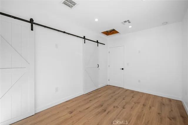 a view of a room with wooden floor and white walls