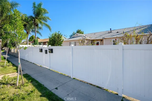 a white building with a big yard and a large tree
