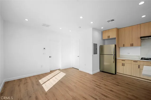 a kitchen with a refrigerator and a stove top oven