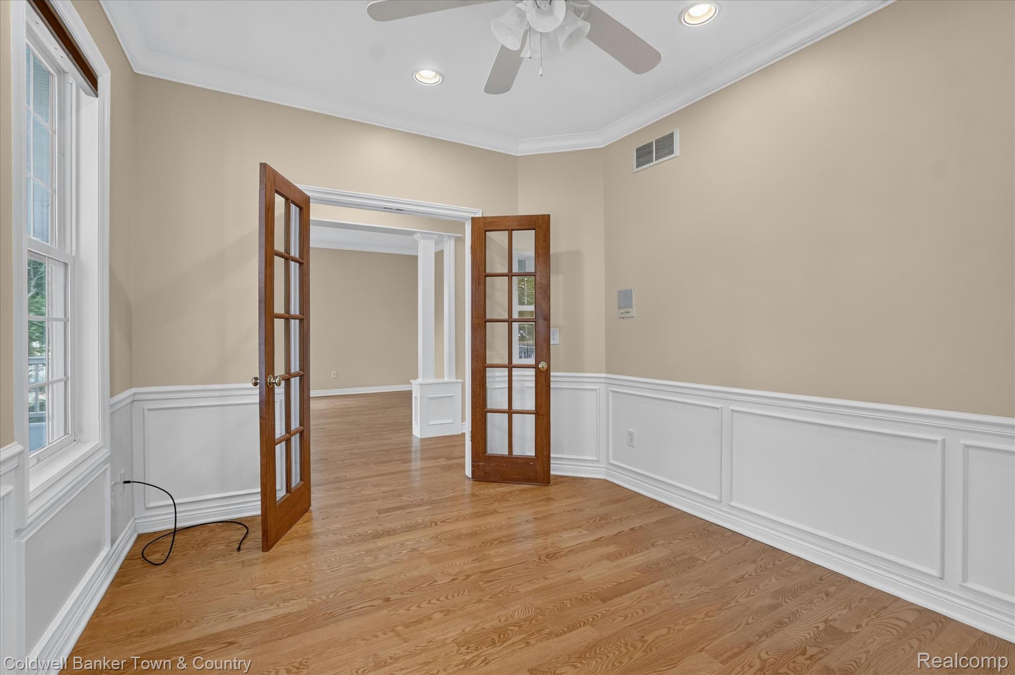 1725 Town Commons Drive Howell, MI 48855 - Photo 11 of 53 Room featuring wood-finish flooring, white wainscoting, and a neutral wall color