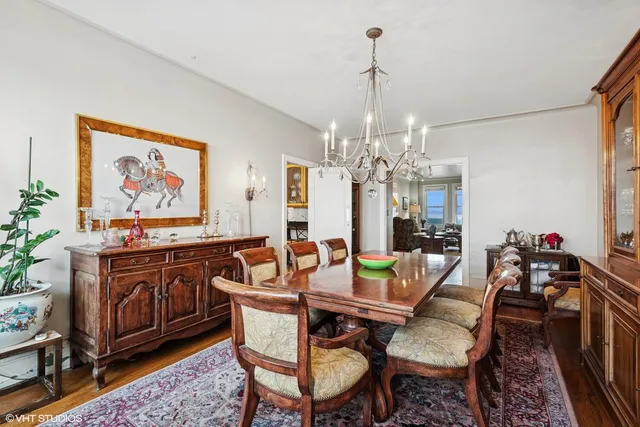 a view of a dining room with furniture a chandelier and wooden floor