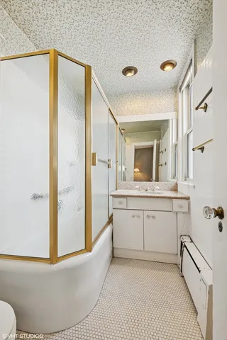 a bathroom with a granite countertop sink mirror and a bathtub