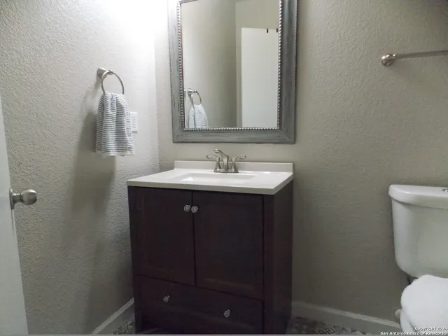 a bathroom with a sink vanity and toilet
