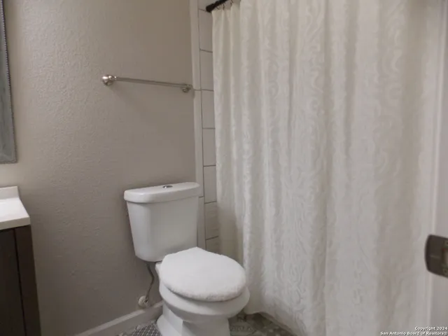 a white toilet sitting next to a shower