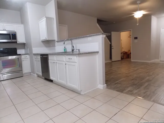 a kitchen with granite countertop white cabinets and stainless steel appliances