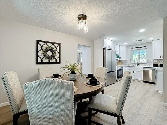 a bedroom with a bed a chandelier and a dresser