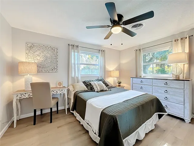 a bedroom with bed couches and a flat tv screen