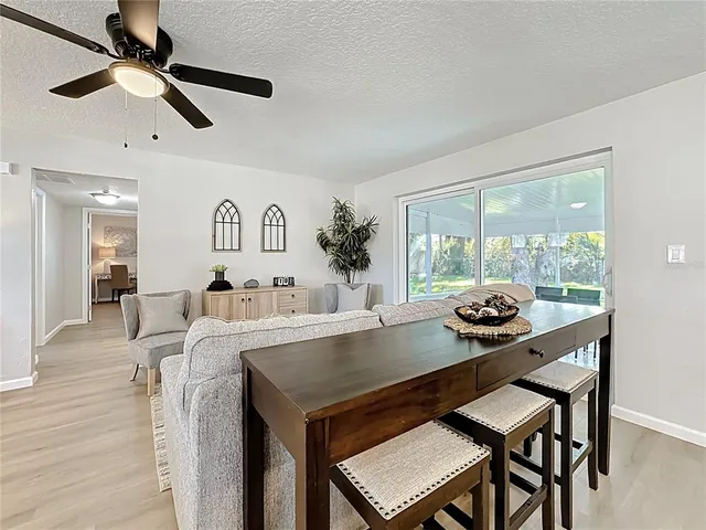 a kitchen with sink a microwave and chairs