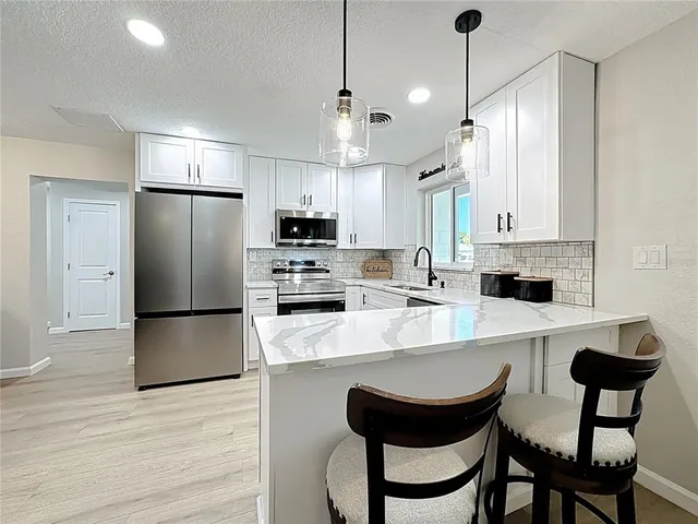 a view of a dining room with furniture and a chandelier