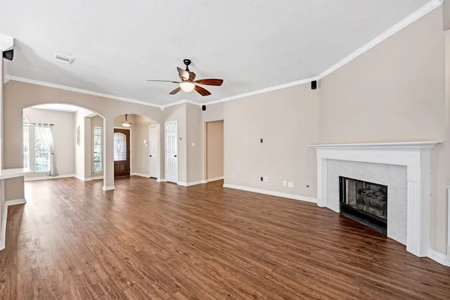 a view of a livingroom with wooden floor and a fireplace