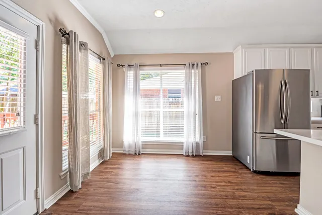 a view of a kitchen with wooden floor and refrigerator