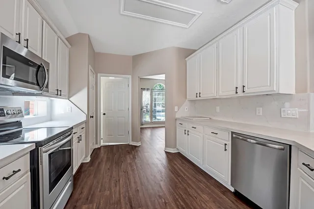 a kitchen with granite countertop cabinets stainless steel appliances and wooden floor