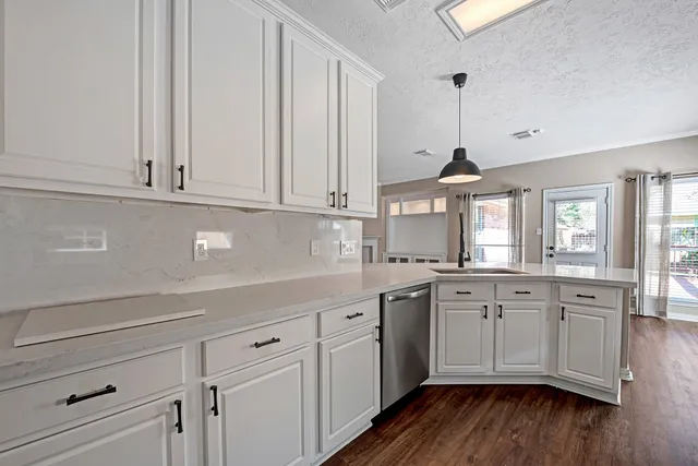 a kitchen with granite countertop white cabinets and white appliances