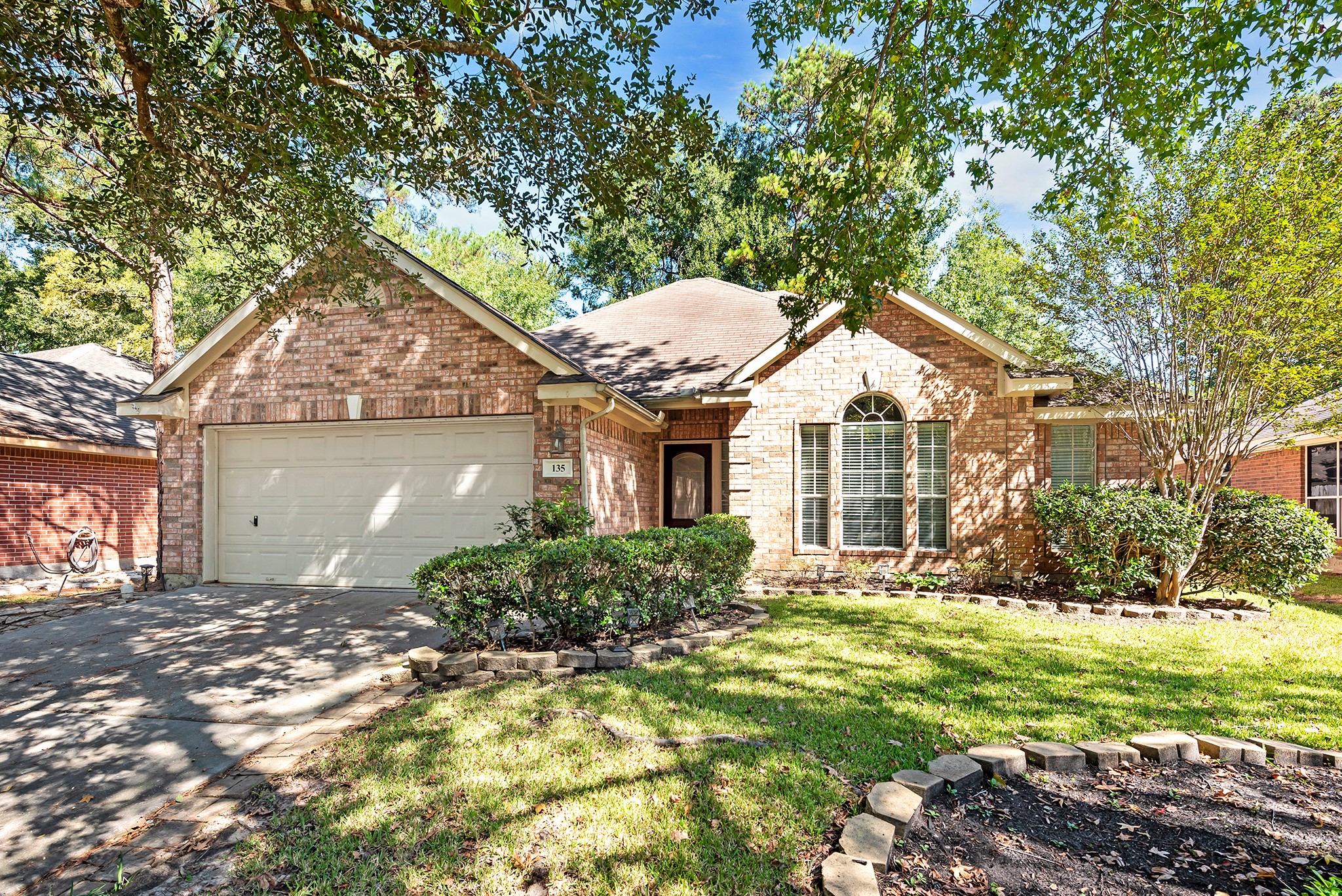 135 West Russet Grove Circle The Woodlands, TX 77384 - Photo 2 of 31 a front view of a house with a yard and potted plants