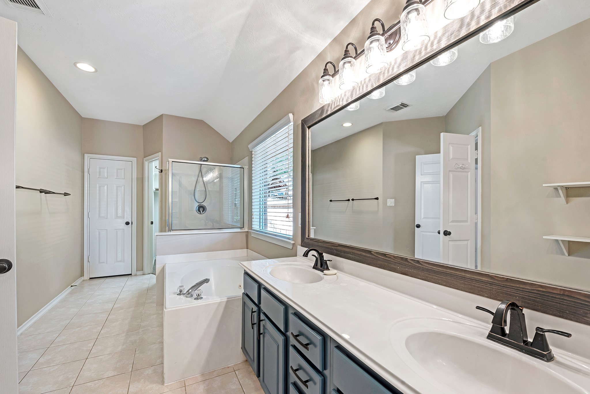 135 West Russet Grove Circle The Woodlands, TX 77384 - Photo 27 of 31 a spacious bathroom with a double vanity sink a mirror and a shower