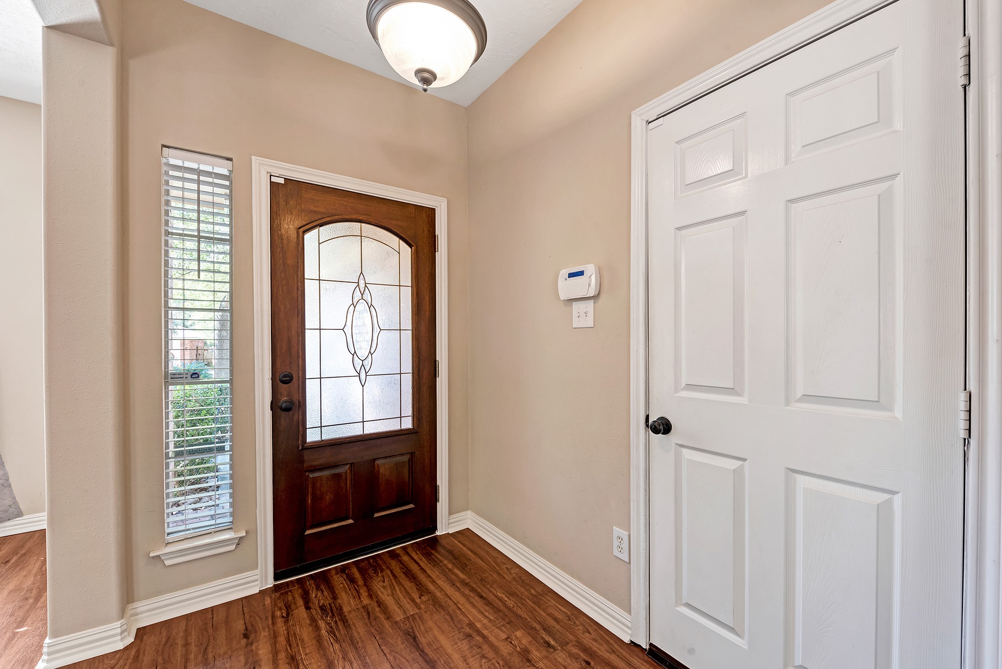 135 West Russet Grove Circle The Woodlands, TX 77384 - Photo 7 of 31 an empty room with wooden floor mirror and windows