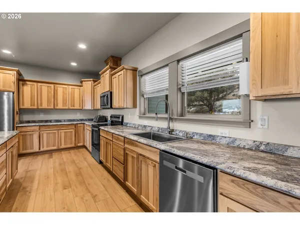 a kitchen with granite countertop a sink stove and cabinets
