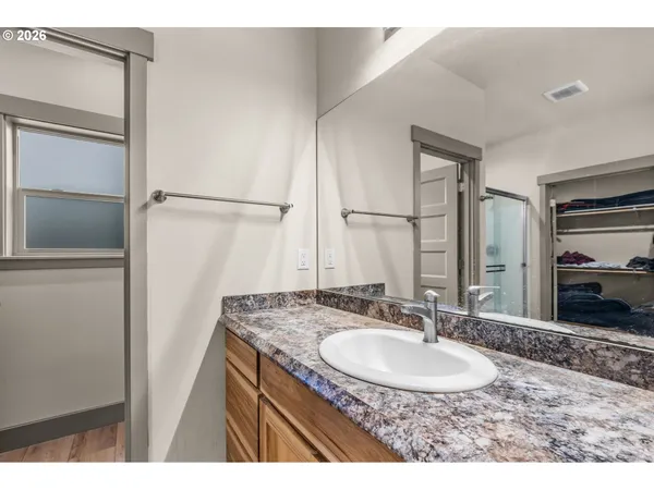 a bathroom with a granite countertop sink a large mirror and a bathtub