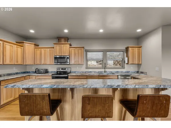 a kitchen with stainless steel appliances granite countertop a sink stove and cabinets