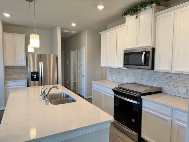 a kitchen with stainless steel appliances kitchen island a refrigerator sink and microwave