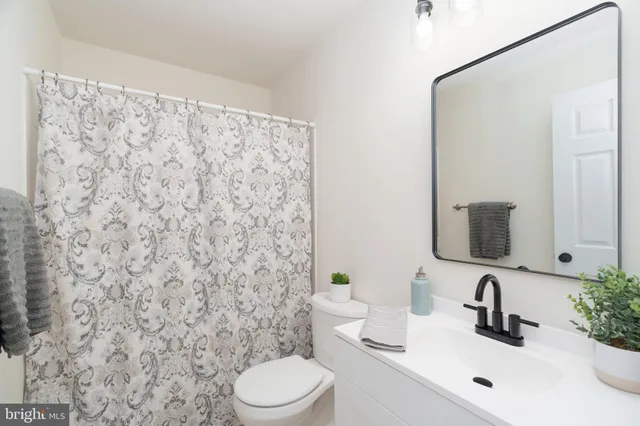 a bathroom with a sink a toilet and a mirror