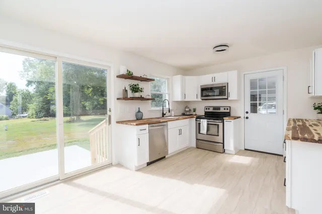 a kitchen with granite countertop a stove a sink and a refrigerator