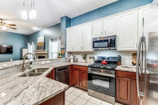 a kitchen with stainless steel appliances granite countertop a sink a stove and a microwave