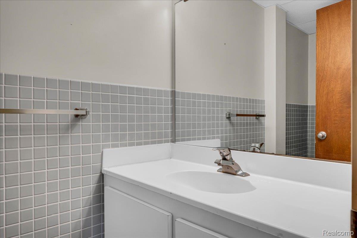1156 Seneca Road Lake Orion, MI 48362 - Photo 35 of 50 Bathroom with tile walls, vanity, and a wainscoted wall
