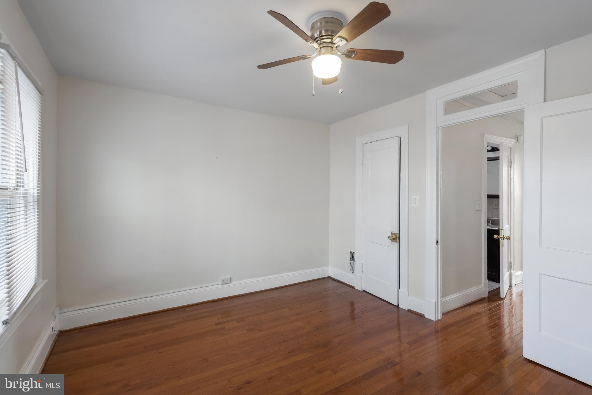 1841 L Street Northeast Washington, DC 20002 - Photo 13 of 31 an empty room with wooden floor chandelier fan and windows