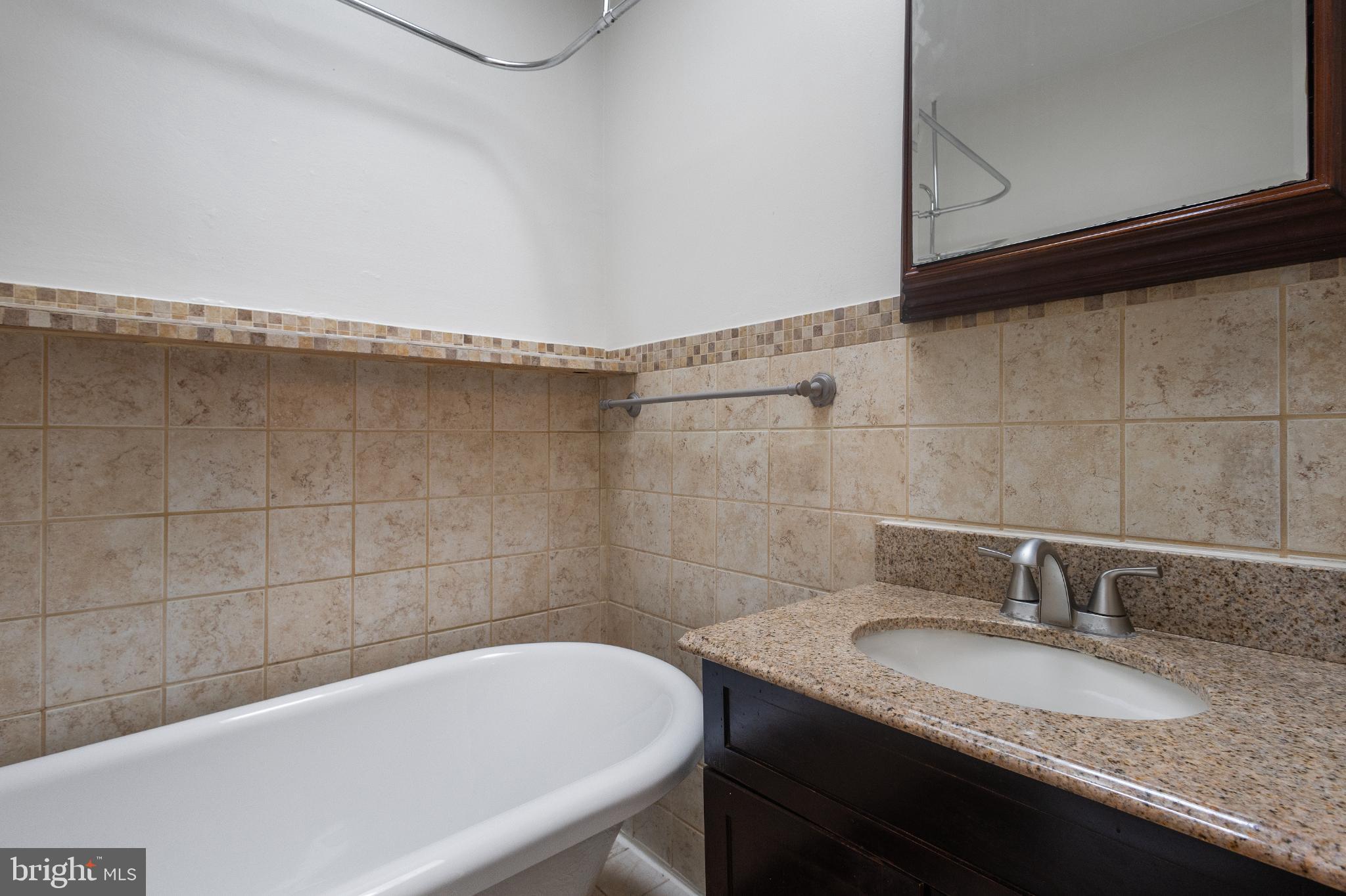 1841 L Street Northeast Washington, DC 20002 - Photo 14 of 31 a bathroom with a granite countertop sink and a bathtub