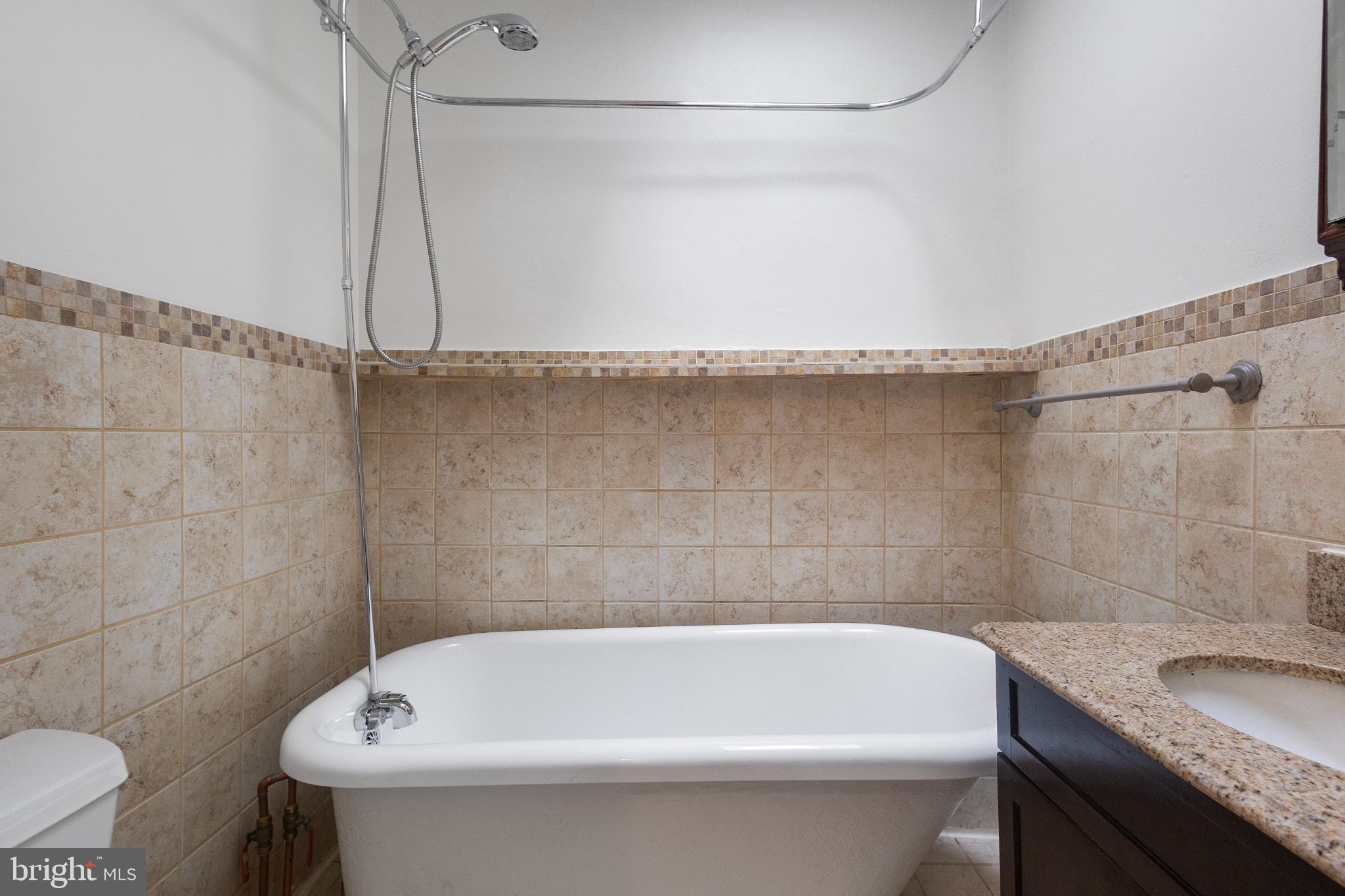 1841 L Street Northeast Washington, DC 20002 - Photo 15 of 31 a bathroom with a granite countertop sink a toilet and bathtub