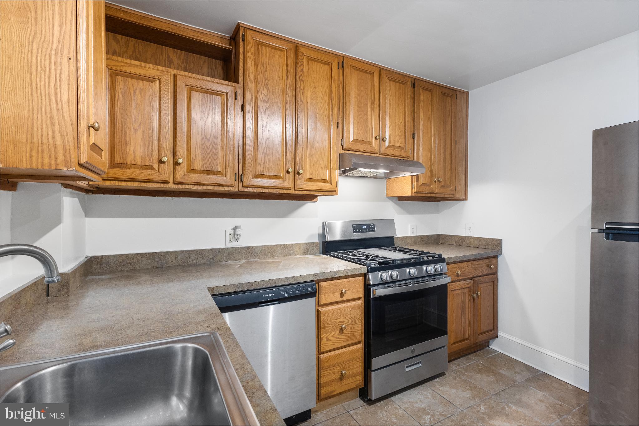1841 L Street Northeast Washington, DC 20002 - Photo 6 of 31 a kitchen with granite countertop a sink stove and cabinets