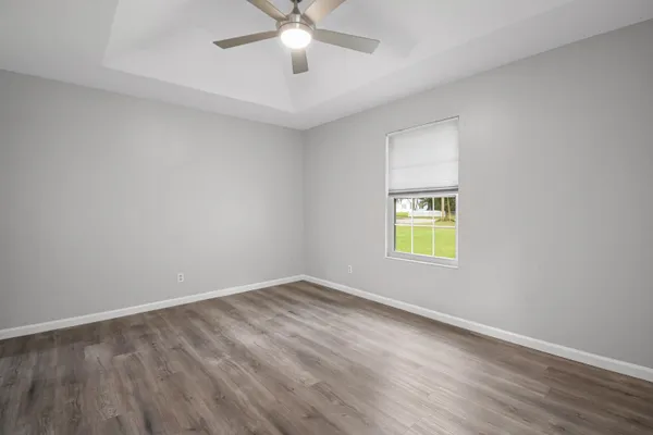 an empty room with a window and a fan