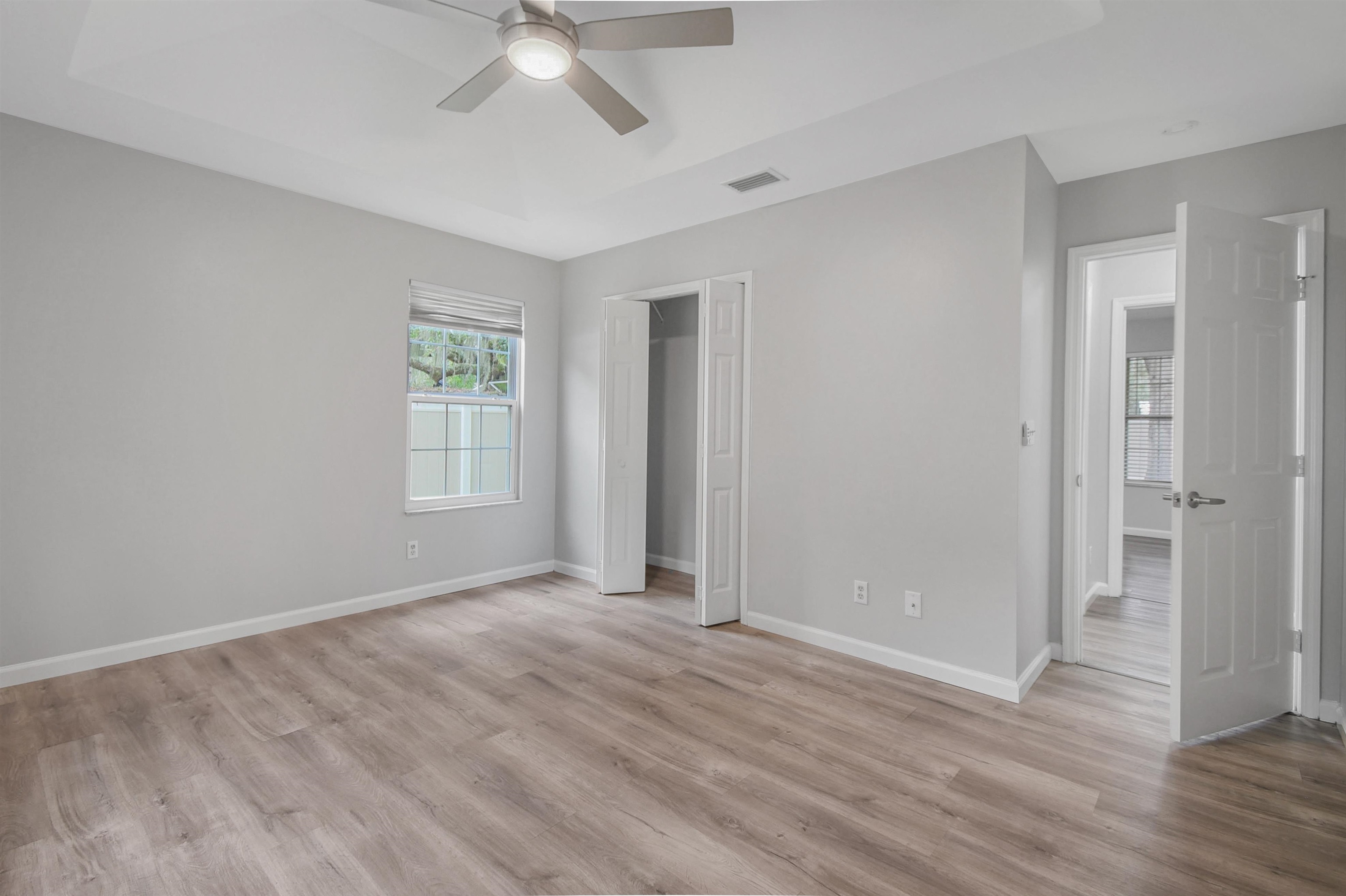 1196 Brookside Court St. Augustine, FL 32086 - Photo 19 of 29 an empty room with wooden floor ceiling fan and windows