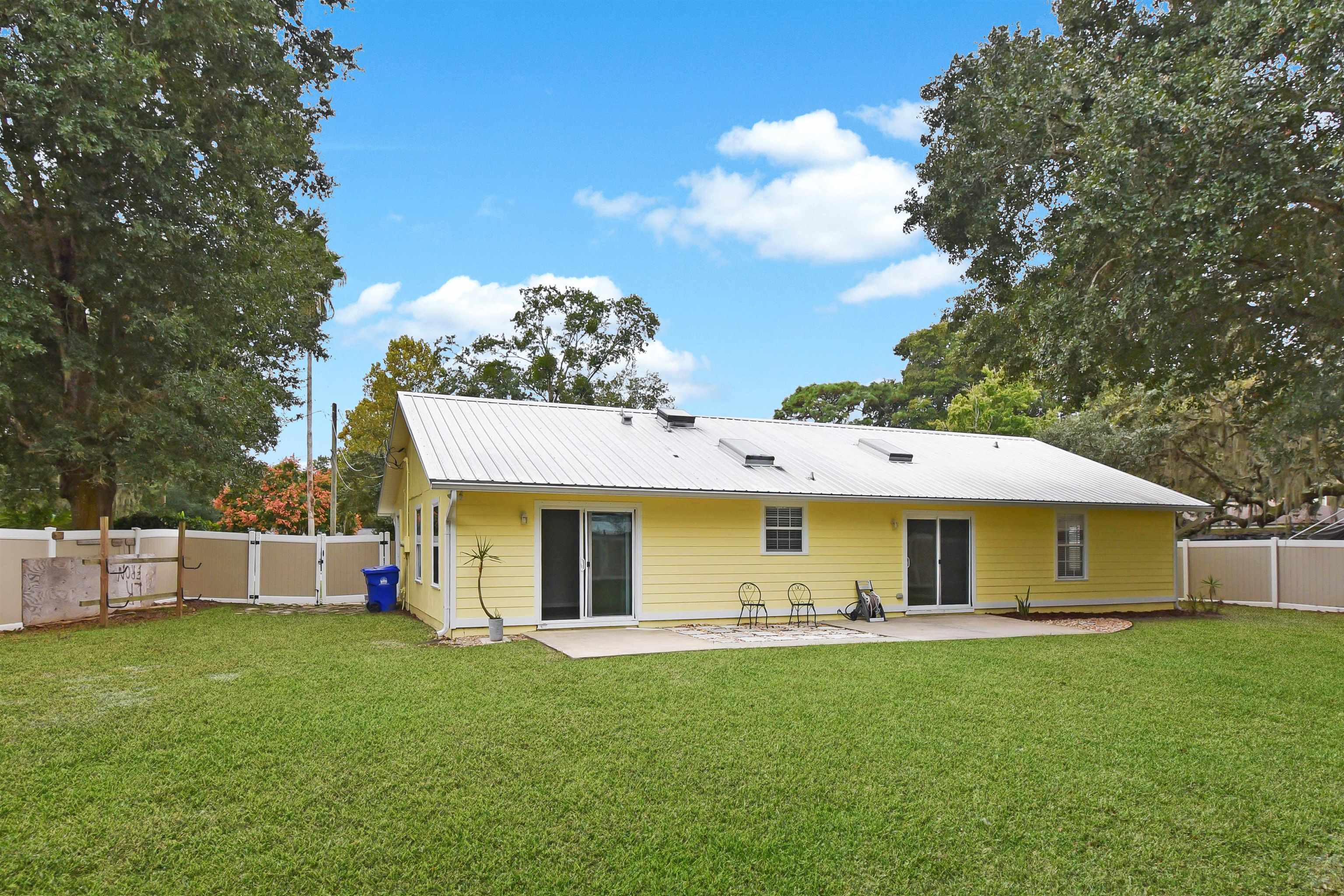 1196 Brookside Court St. Augustine, FL 32086 - Photo 6 of 29 a view of a yard with table and chairs under an umbrella