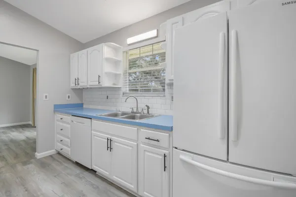 a kitchen with white cabinets and white appliances