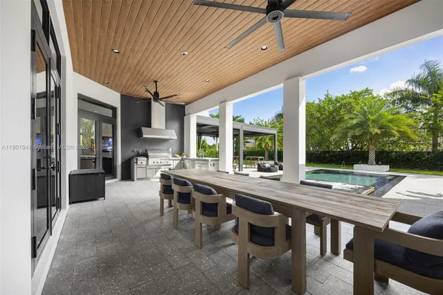 a view of a patio with a table and chairs and a barbeque