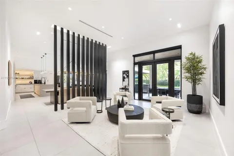a living room with furniture a flat screen tv and kitchen view