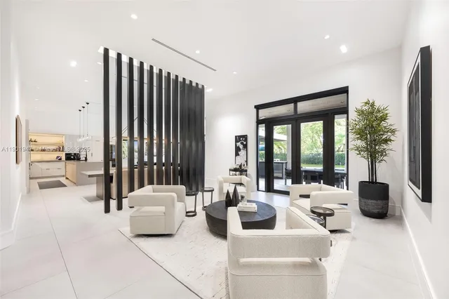 a living room with furniture a flat screen tv and kitchen view