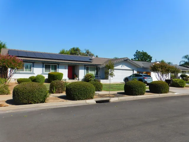 a front view of a house with a yard and outdoor seating
