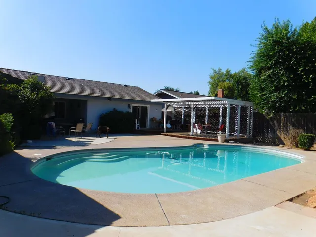 a view of a house with swimming pool and a yard