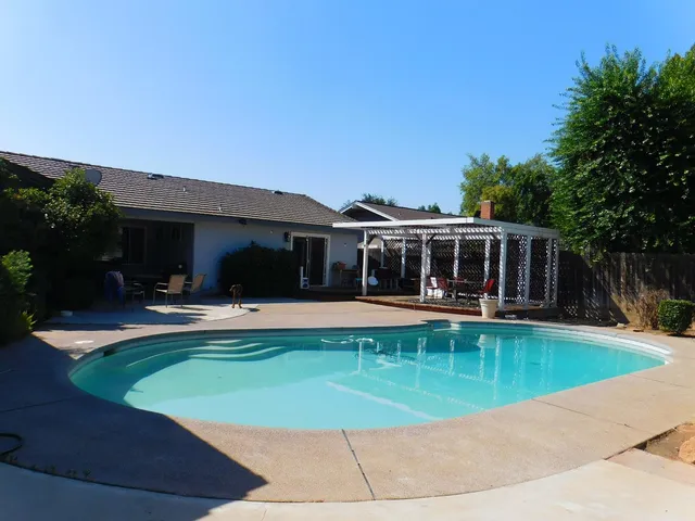 a view of house with swimming pool yard and outdoor seating